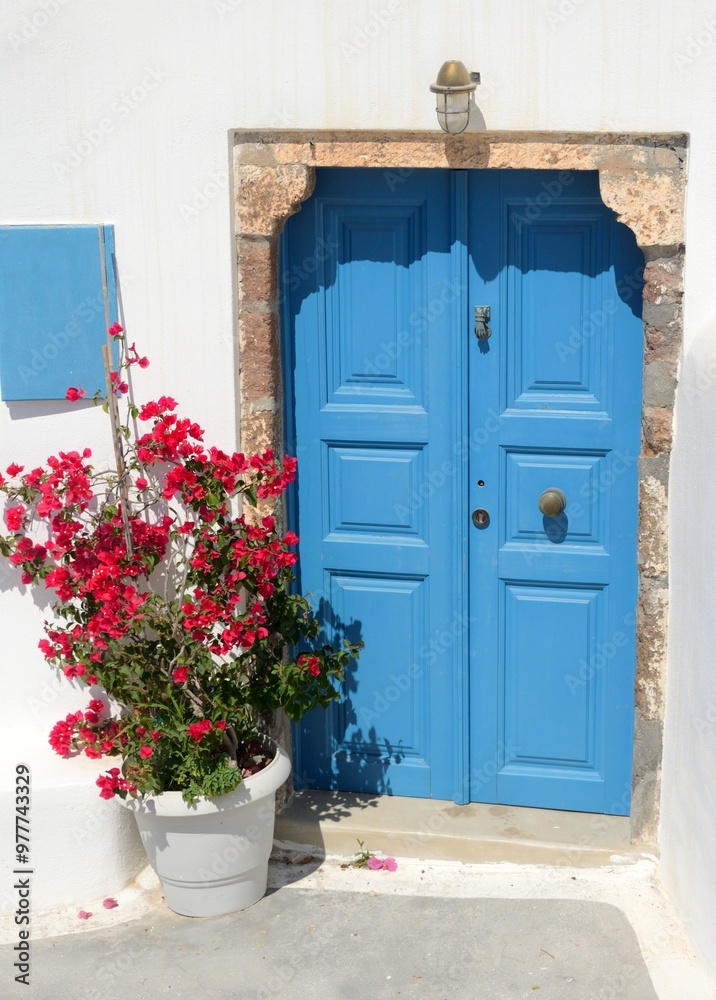 Fototapeta premium Puerta azul y casa blanca en Pyrgos, isla de Santorini, Grecia