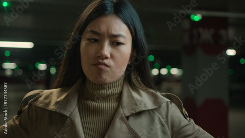 Doubtful unsure thoughtful young Asian woman girl korean chinese japanese ethnic girl puzzled thinking female businesswoman in car parking lot ponder ideas thoughts difficult decision doubt question photo