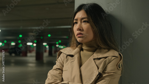 Upset anxious stressful Asian chinese woman female girl alone in car parking underground think difficult thoughts worried bad memories quarrel problem trouble suffer depression fatigue stress sorrow photo