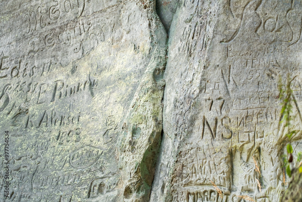 Obraz premium Carvings and Graffiti Etched Into Weathered Rock