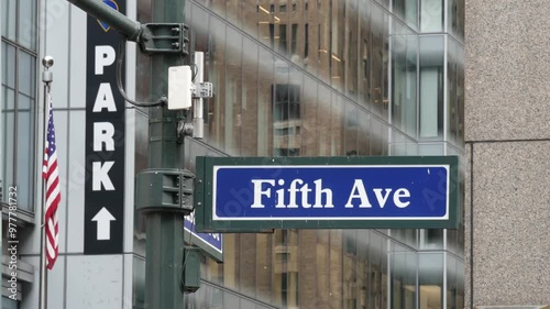 Fifth avenue, 5 ave road sign, Manhattan midtown architecture, New York City 5th av street corner. Traffic crossroad signage, USA. Parking garage and american flag.