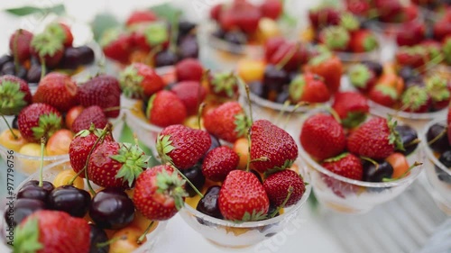 Beautifully decorated banquet catering table, assortment variety of berries with cherry, strawberry, raspberry and apricot, on luxury birthday party event or wedding reception celebration photo