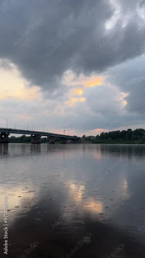 raindrops with circles on the water on the background of the bridge over the river raindrops with circles on the water on the background of the bridge over the river