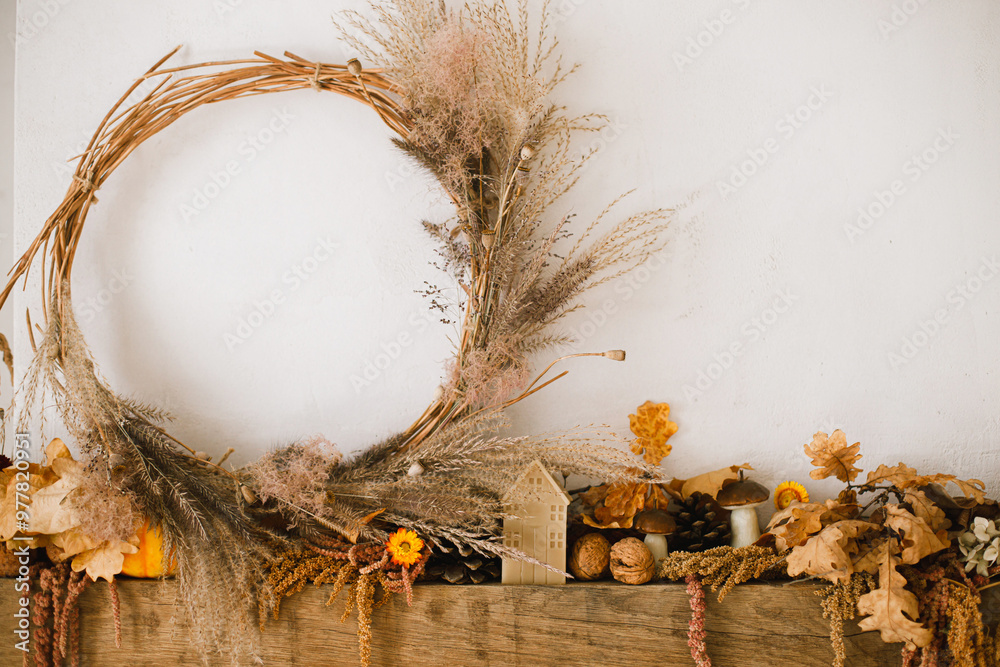 Φωτογραφία Stylish decoration of fireplace with pumpkins, wreath, autumn leaves, nuts, candle on rustic wood in modern farmhouse living room