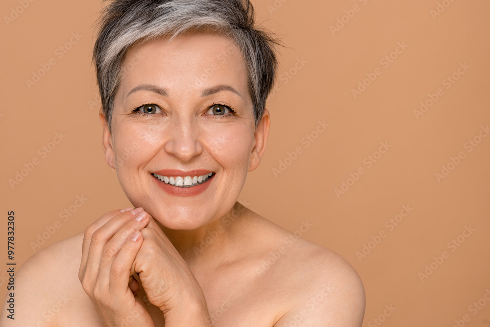 Portrait, skincare and mature woman with anti aging in studio for cosmetology, dermatology or natural glow on beige background. Wellness, hands and model person for facial, spa treatment or cosmetics Portrait, skincare and mature woman with anti aging in studio for cosmetology, dermatology or natural glow on beige background. Wellness, hands and model person for facial, spa treatment or cosmetics