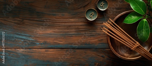 Flat lay arrangement featuring incense sticks on a wooden table with space for text Om ligature. Copy space image. Place for adding text and design