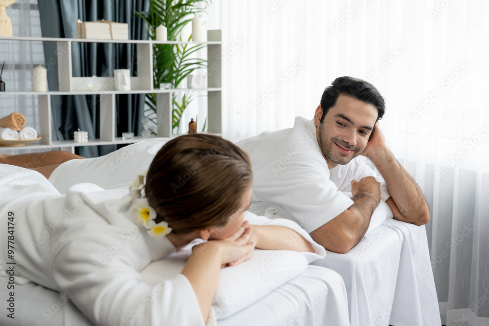 Caucasian couple customer enjoying relaxing anti-stress spa massage and pampering with beauty skin recreation leisure in day light ambient salon spa at luxury resort or hotel. Quiescent Caucasian couple customer enjoying relaxing anti-stress spa massage and pampering with beauty skin recreation leisure in day light ambient salon spa at luxury resort or hotel. Quiescent