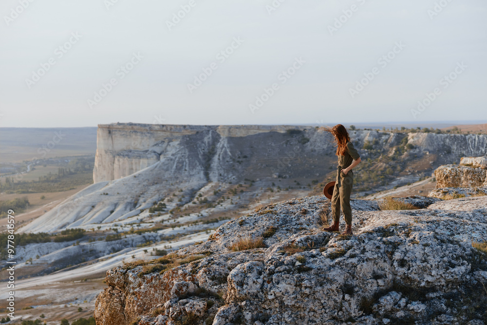 Woman standing on cliff overlooking stunning valley landscape beauty and tranquility Woman standing on cliff overlooking stunning valley landscape beauty and tranquility
