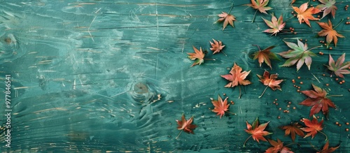 Autumn maple leaves on a weathered green wooden surface with copy space