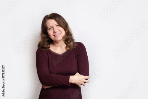Fotografie A smug middle-aged woman hugs herself and smiles, she is happy that she got rid of depression and panic attacks in life