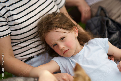 Little cute girl sitting on her mother's arms. Concept of bonding between child and parent