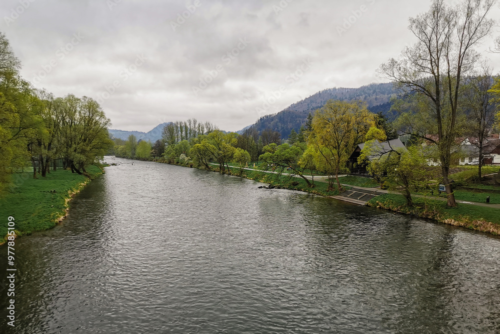 Rzeka Dunajec - Krościenko nad Dunajcem. Widok z mostu. W tle góry Pieniny. Pochmurny wiosenny dzień. Rzeka Dunajec - Krościenko nad Dunajcem. Widok z mostu. W tle góry Pieniny. Pochmurny wiosenny dzień.