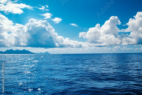 Stunning ocean seascape with blue water, white clouds and islands on the horizon