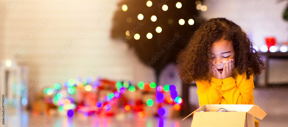 © Prostock-studio - My wish. Shocked happy african american little girl enjoying Christmas gift near Xmas tree, free space © Prostock-studio - My wish. Shocked happy african american little girl enjoying Christmas gift near Xmas tree, free space