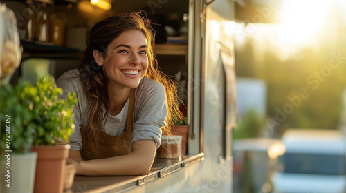 Smiling woman in a food truck with plants, enjoying sunlight