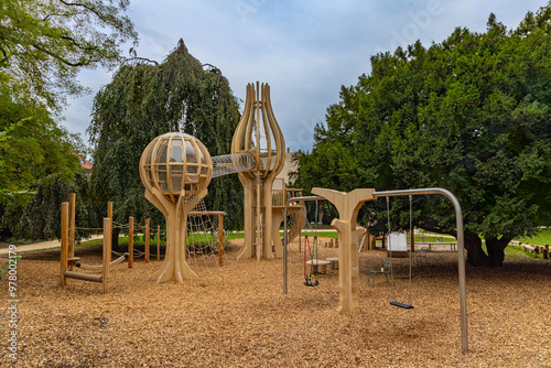 Fototapeta Naklejka Na Ścianę i Meble -  Modern children's playground with wooden material in creative forms and structures in a public garten