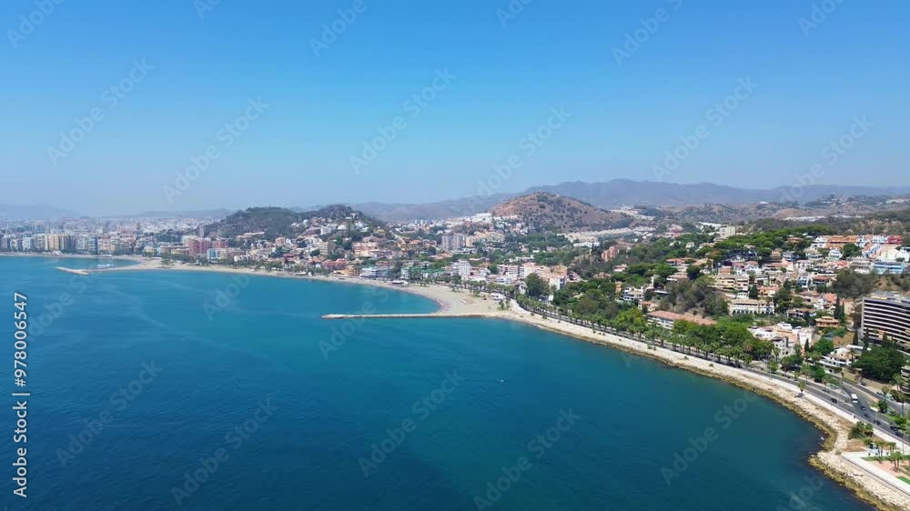 Aerial view over the coastline of Malaga overlooking the sea shore, mediterranean road, Pedregalejo district, residential area, beach and mountains in the background. Aerial view over the coastline of Malaga overlooking the sea shore, mediterranean road, Pedregalejo district, residential area, beach and mountains in the background.
