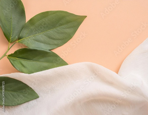 Fresh green leaves contrast against the light orange background, decorated with soft white fabric. generative ai photo