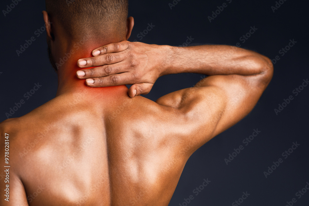 Back View. Shirtless black man suffering from pain in neck, symptom of cervical chondrosis, red spot, trauma Back View. Shirtless black man suffering from pain in neck, symptom of cervical chondrosis, red spot, trauma
