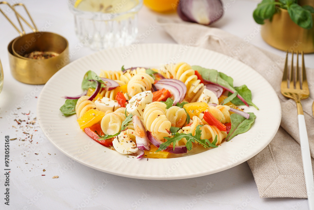 Plate of tasty pasta salad with pepper and red onion on white background Plate of tasty pasta salad with pepper and red onion on white background