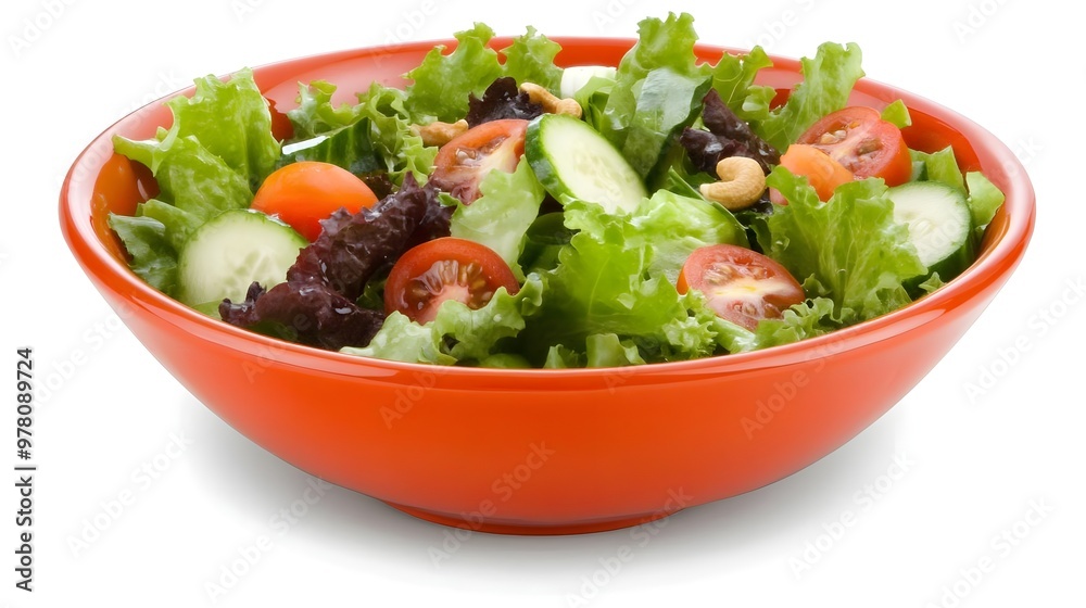 Fresh mixed salad in a vibrant orange bowl, featuring crisp lettuce, cherry tomatoes, and sliced cucumbers. Perfect for healthy meals. Fresh mixed salad in a vibrant orange bowl, featuring crisp lettuce, cherry tomatoes, and sliced cucumbers. Perfect for healthy meals.
