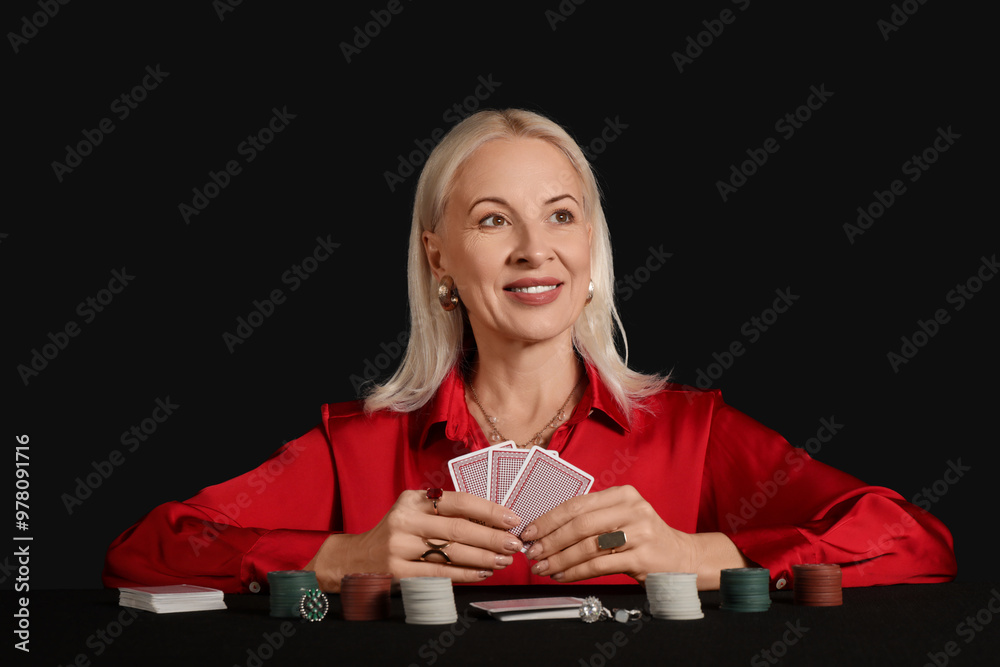 Φωτογραφία Fashionable mature woman in beautiful earrings and rings playing poker at table