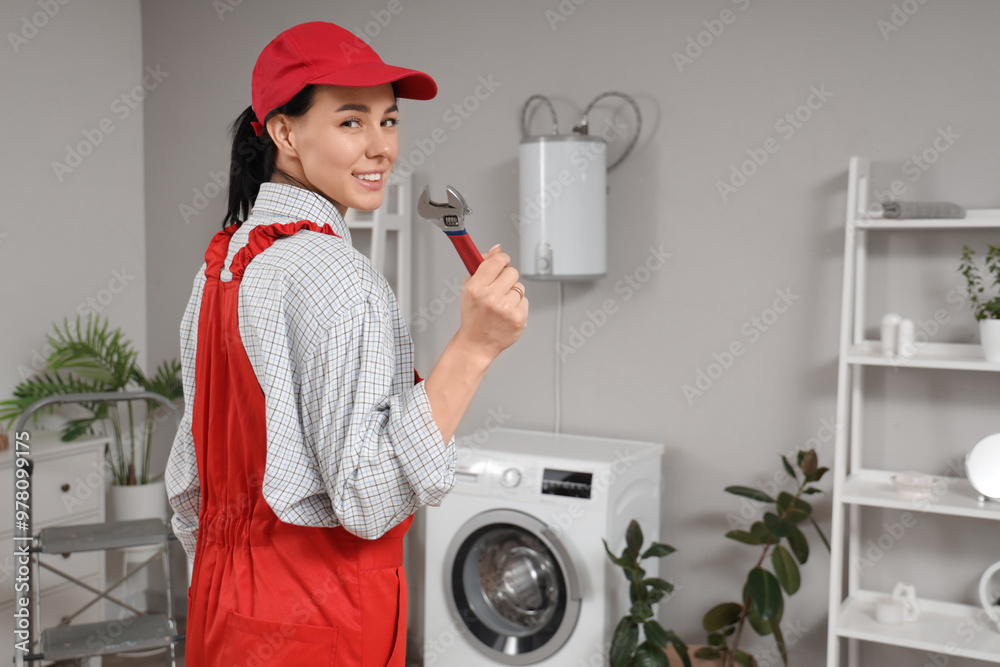 Obraz na plátně Female worker with wrench near modern electric boiler in bathroom
