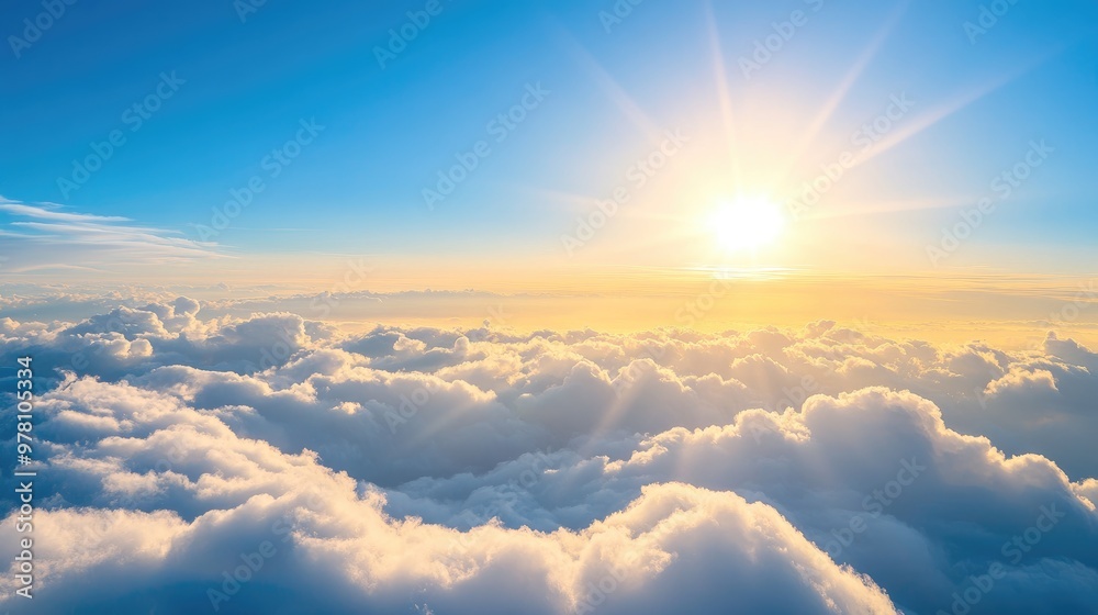 Stunning view above thick clouds from an airplane, with a clear blue sky and the sun's rays gently illuminating the cloud tops Stunning view above thick clouds from an airplane, with a clear blue sky and the sun's rays gently illuminating the cloud tops