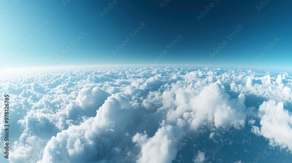A panoramic view of fluffy white clouds floating across a bright blue sky, with the horizon barely visible. A panoramic view of fluffy white clouds floating across a bright blue sky, with the horizon barely visible.