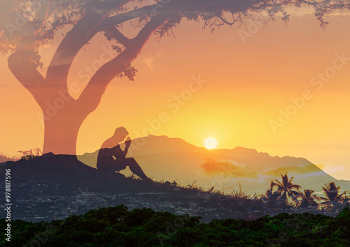 Young man praying to god in the sunset 