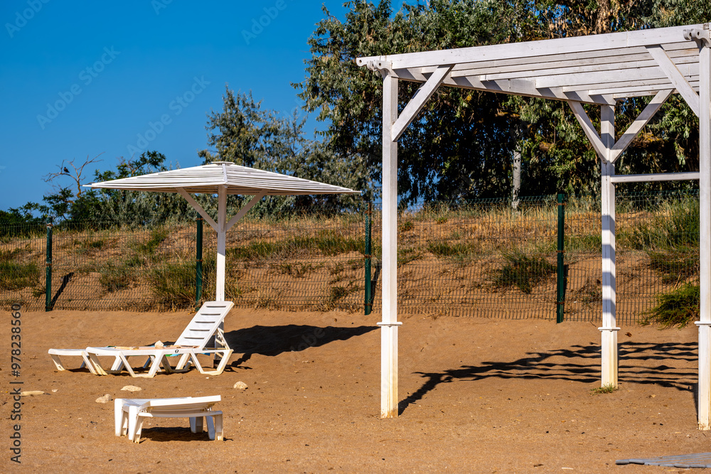 A canopy with a sun lounger on a sandy beach in summer. A canopy with a sun lounger on a sandy beach in summer.