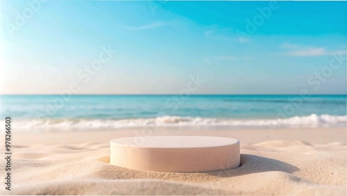 A white container on sandy beach, with ocean waves in the background, ideal for summer product presentations.