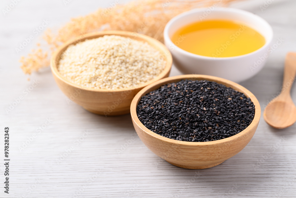Black and white sesame seeds and oil (Cold pressed) in bowl on white table, Food ingredient Black and white sesame seeds and oil (Cold pressed) in bowl on white table, Food ingredient