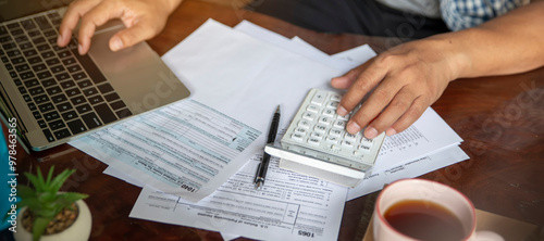 Budget and Tax planning concept. Acountant hand using calculator and review tax form. Represents personal finance, tax preparation, and budgeting, season to pay tax-banner image. photo