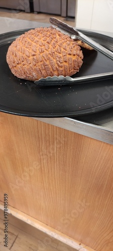 A pair of tongs holding a delicious chocolate shell on the tray,,Un par de pinzas sosteniendo Una  deliciosa concha de chocolate sobre la  charola,  photo