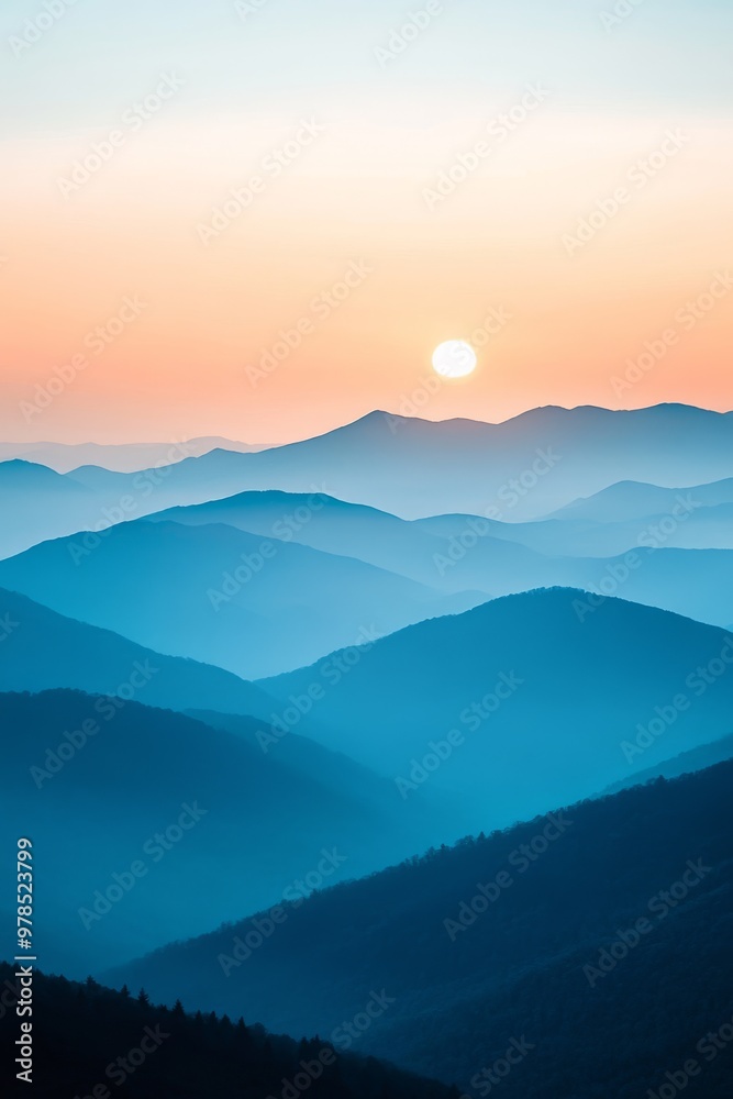 Serene sunrise over rolling mountains with soft blue hues and distant peaks gently illuminated by early morning light Serene sunrise over rolling mountains with soft blue hues and distant peaks gently illuminated by early morning light