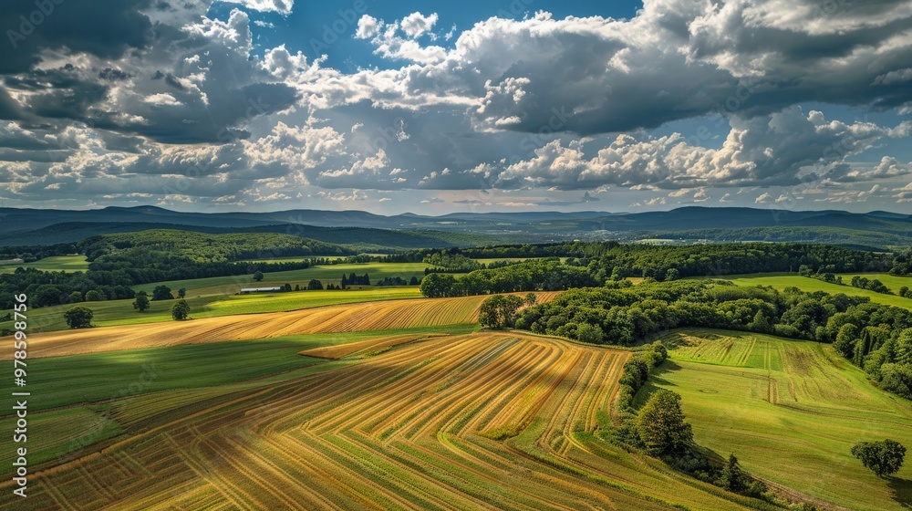 Obraz premium Clouds casting shadows over a patchwork of fields