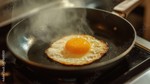Fried egg sizzling in pan, creating delicious aroma and steam
