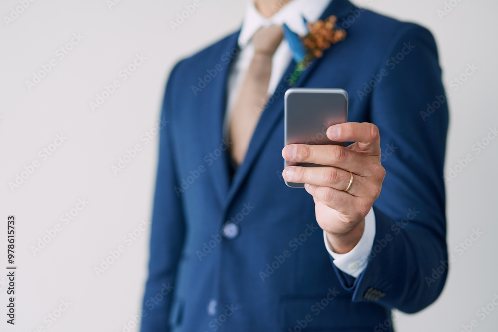 Hand, groom and smartphone in studio for marriage with digital, wedding schedule and relationship trust. Social media, status update and commitment for man, suit and partnership on white background Hand, groom and smartphone in studio for marriage with digital, wedding schedule and relationship trust. Social media, status update and commitment for man, suit and partnership on white background
