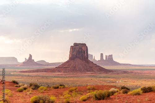 Monument Valley's buttes under a soft, cloudy sky with desert