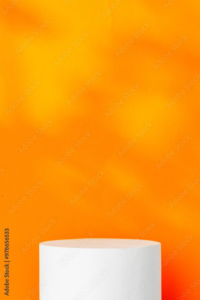 White cylindrical display on a bright orange background White cylindrical display on a bright orange background