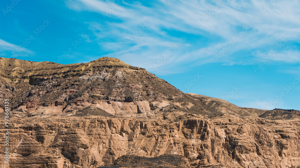 high rocky mountains in the desert against the blue sky and white clouds in Egypt Dahab South Sinai high rocky mountains in the desert against the blue sky and white clouds in Egypt Dahab South Sinai