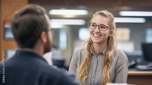 A friendly bank employee smiling while discussing loan options with a customer in a modern bank office. photo