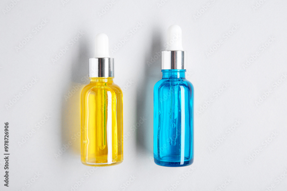 Essential oils in bottles on light background, top view Essential oils in bottles on light background, top view