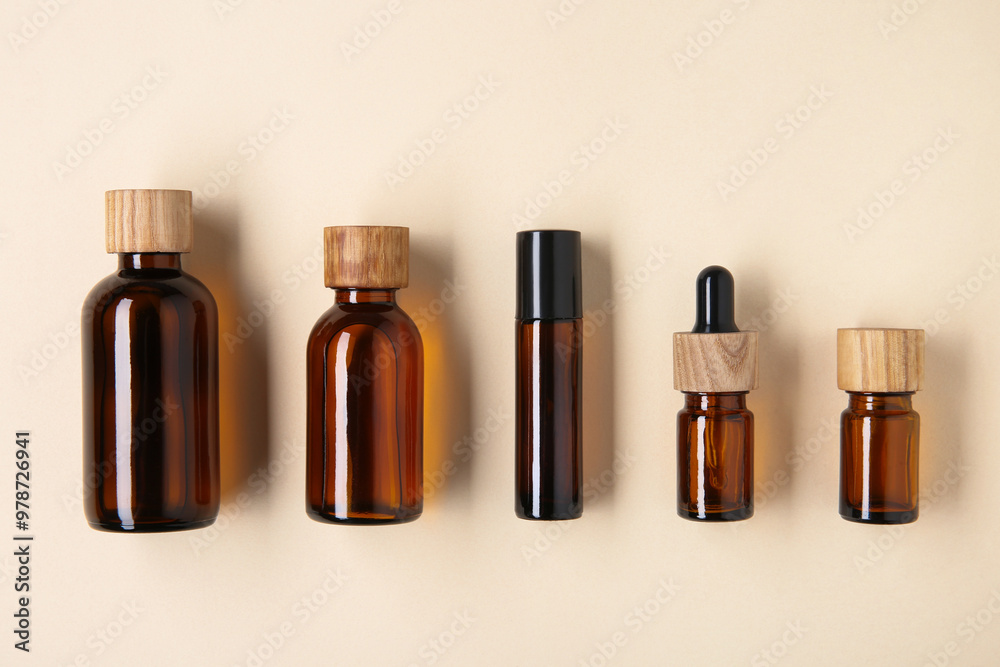 Essential oils in bottles on beige background, flat lay Essential oils in bottles on beige background, flat lay
