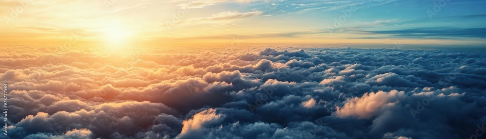 A breathtaking view of the sun rising above a sea of fluffy clouds, creating a serene and picturesque atmosphere.