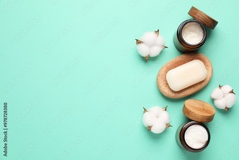 Different cosmetic products and cotton flowers on turquoise background, flat lay. Space for text