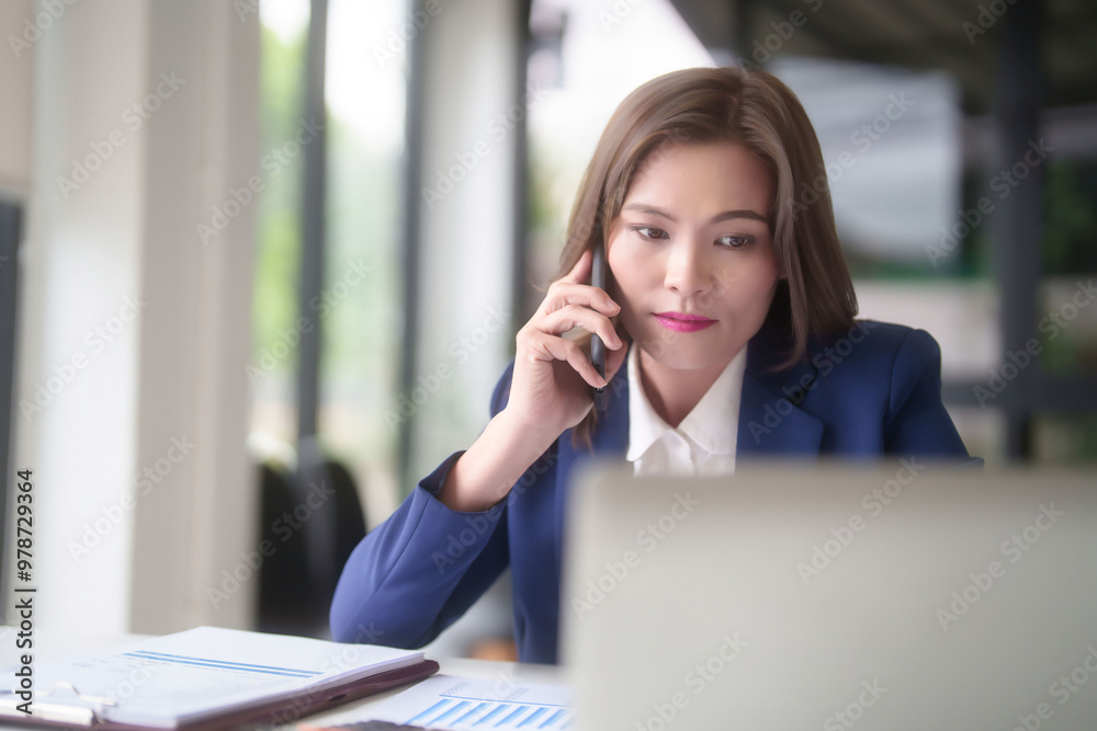 Asian businesswomen using smartphone to talking with colleague and typing on keyboard laptop to researching business data while analyze investment and market stock of new startup in outside office