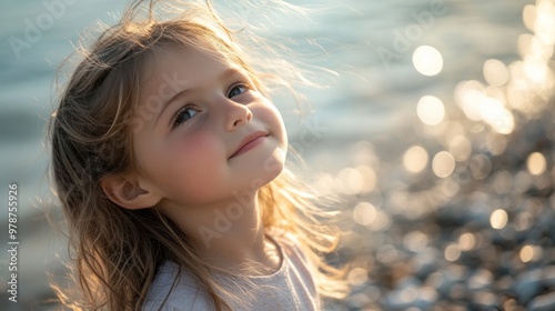 Fototapeta Naklejka Na Ścianę i Meble -  A young Croatian girl with flowing hair, enjoying a sunny day on a pebble beach along the Adriatic coast