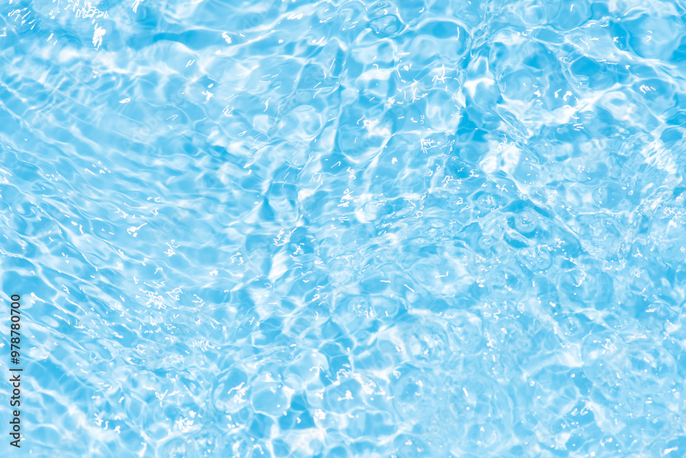 Blue water with ripples on the surface. Defocus blurred transparent blue colored clear calm water surface texture with splashes and bubbles. Water waves with shining pattern texture background.